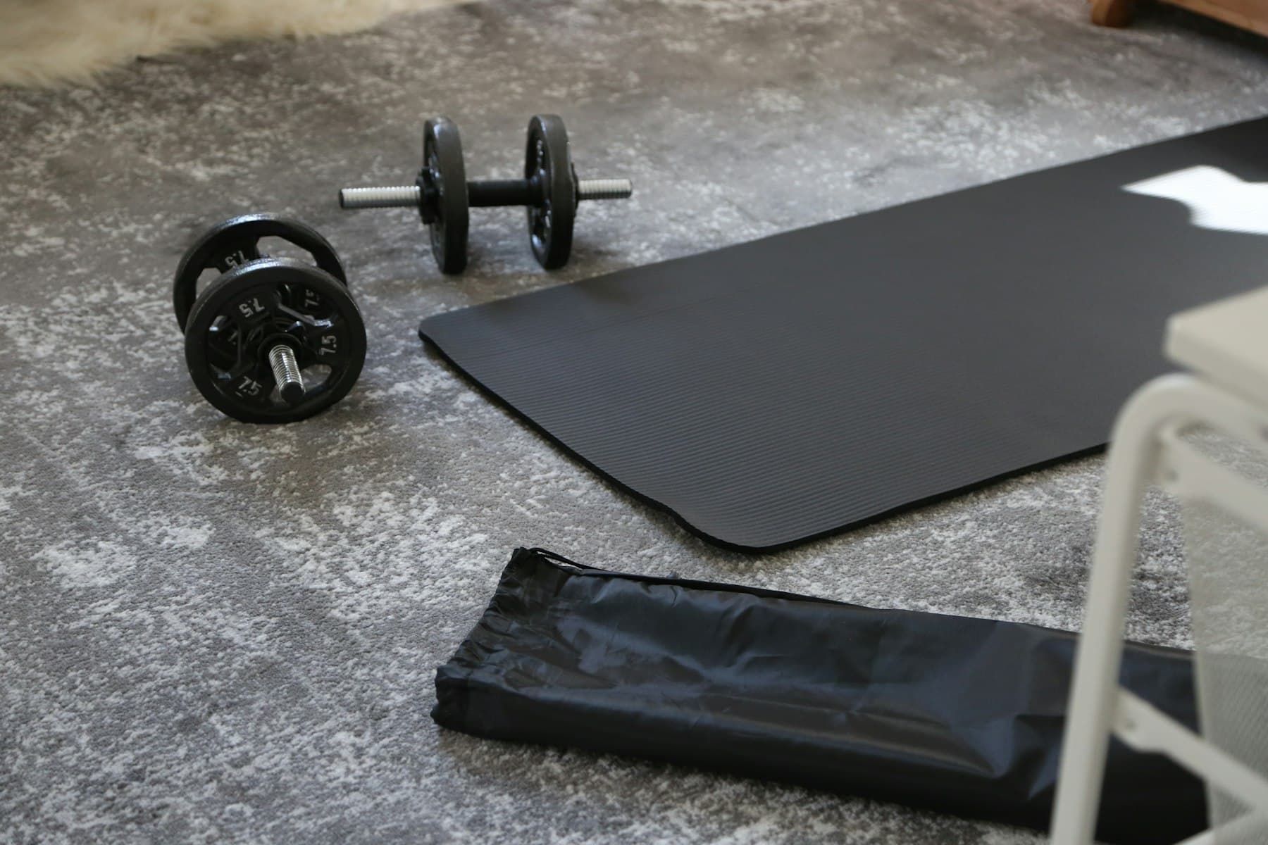 A mat and weights left out on a floor between sessions